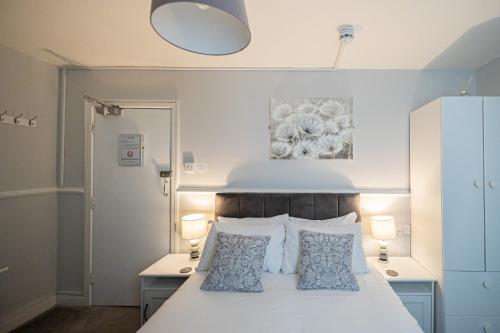 韦茅斯Gresham Guest House的卧室配有白色的床和2个枕头