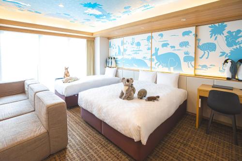 名古屋GOLD STAY Nagoya Osu的客房设有两张床、一张沙发和一张书桌。