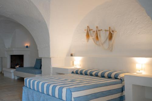 奥斯图尼Oltre gli Ulivi的一间卧室配有一张蓝色和白色条纹的床