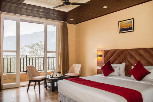 甘托克The Pahuna Retreat的酒店客房设有一张床和一个阳台。