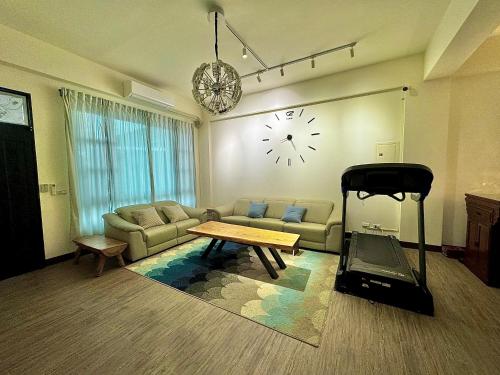 台东澄靛民宿的客厅配有沙发和墙上的时钟