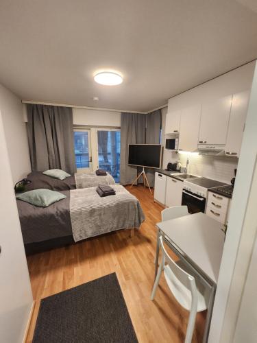 图尔库Viihtyisä täysin kalustettu ja varustettu yksiö Logomolla 1vrk-36kk的一间带床的小卧室和一间厨房