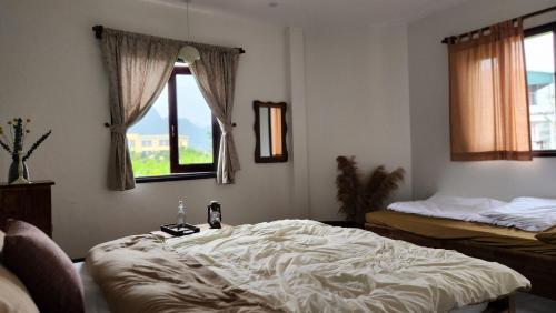河江Anio Ha Giang Hotel的一间设有床铺和窗户的房间