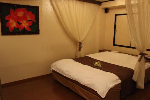 宫崎Ciao-LoveHotel的一间卧室,床上放着鲜花