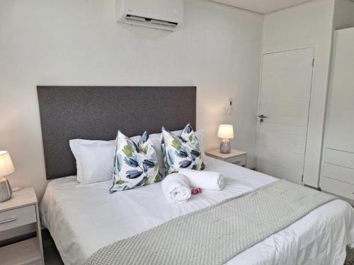 巴利托Simbithi Golf Estate Luxury Apartment的卧室配有带枕头的大型白色床