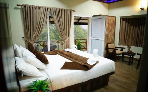 蒙纳The RaaRees Resort - A Hidden Resort in Munnar的一间卧室配有两张带毛巾的床