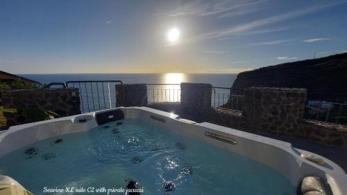 TábuaCastelo do Mar, Madeira的阳台的热水浴池,背景为大海