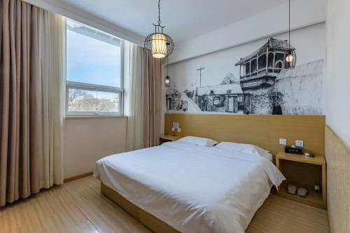 北京春天映向酒店(北京王府井南锣鼓巷店)的一间卧室设有一张大床和一个窗户。