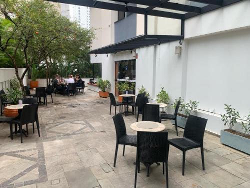 圣保罗Flat Jardim Paulista的庭院配有桌椅,而人们则坐在桌子上