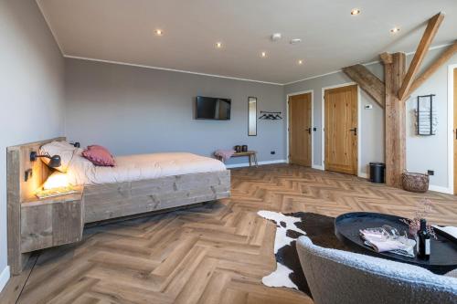 OosterzeeJantje Slot Hoeve的一间卧室设有一张带壁炉的床。