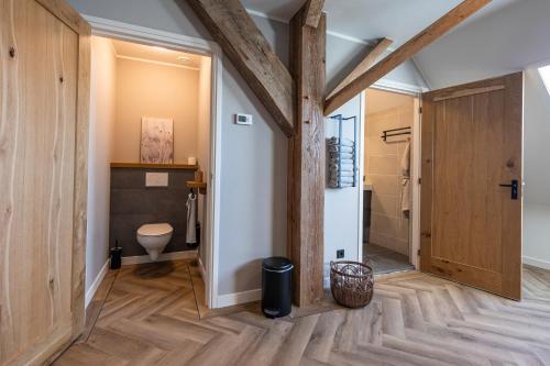 OosterzeeJantje Slot Hoeve的一间带卫生间和木墙的浴室