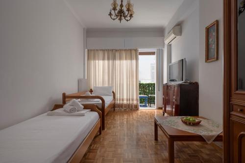 雅典ΔΙΠΛΑ ΣΕ ΜΕΤΡΟ , ΚΟΝΤΑ ΣΤΗΝ ΑΚΡΟΠΟΛΗ的酒店客房设有两张床和一张桌子。