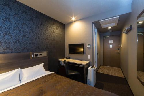 名古屋名古屋桑科酒店 - 固齿新干线的酒店客房配有一张床和一张带电脑的书桌