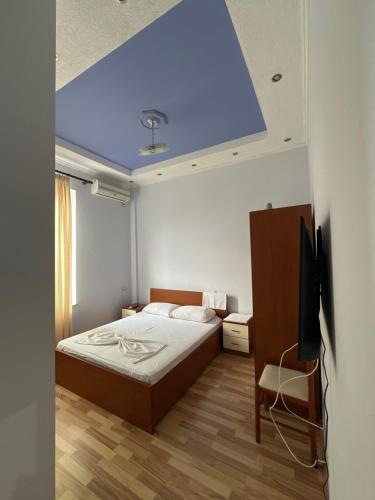 KukësHaliti hotel的一间卧室设有一张床和蓝色的天花板