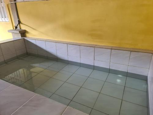 Kuala KeraiAqiza Home Kuala Krai的客房铺有瓷砖地板,设有黄色的墙壁。