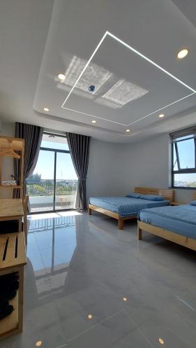 潘切Windy Homestay Phan Thiết的大房间设有两张床和窗户