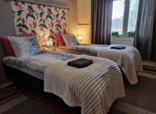 普达斯耶尔维Wanha kunnantalo的酒店客房,配有两张带白色毯子的床