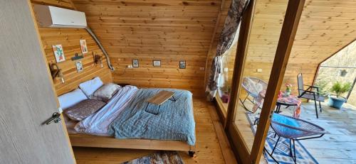 库塔伊西LIMA的木制客房内的一间卧室,配有一张床