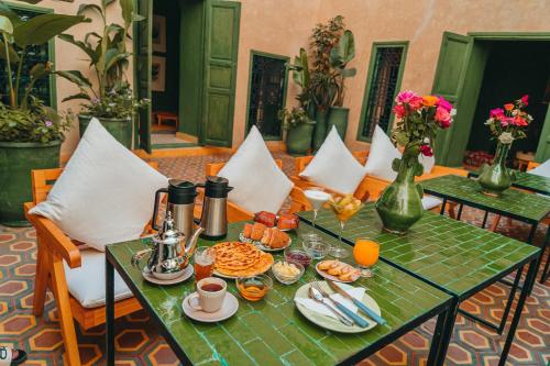 马拉喀什Hotel & Riad Veridis的一张绿桌,上面有早餐食品