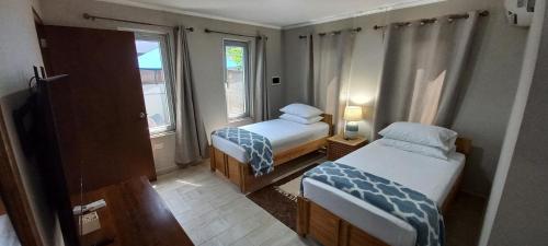 棕榈滩SEMEREL APARTMENT的小房间设有两张床和窗户