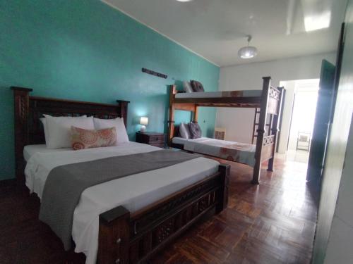 阿拉胡埃拉Lajuela BnB & Hostel的卧室设有两张床铺和绿色的墙壁