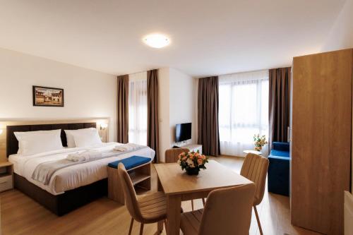 班斯科Green Wood Hotel & Spa Bansko的酒店客房配有一张床铺和一张桌子。