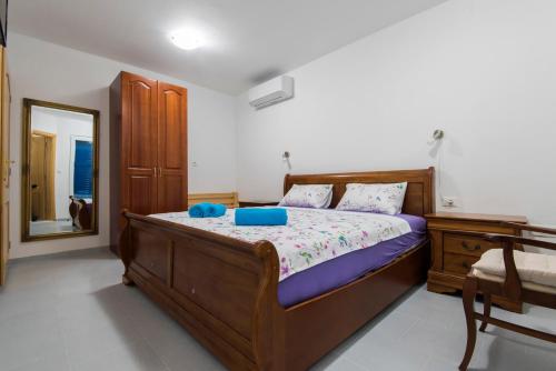 苏科尚Vila Niko Dalmacija的一间卧室配有一张带蓝色枕头和镜子的床