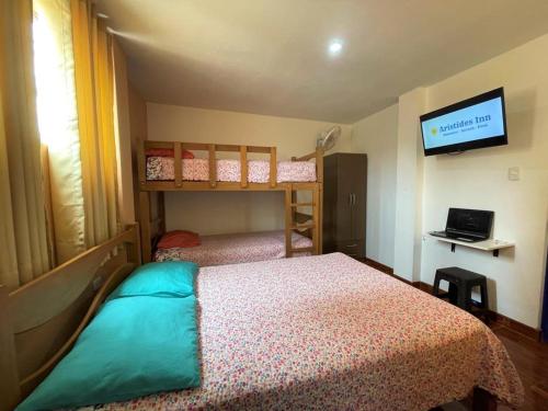 瓦尔梅Aristides Inn的一间卧室配有两张双层床和一台平面电视