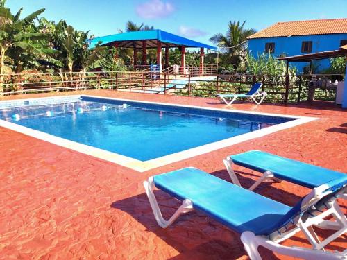 圣塔芭芭拉-山美纳Paraíso de Rojas hotel的一个带两把椅子和一张桌子的游泳池