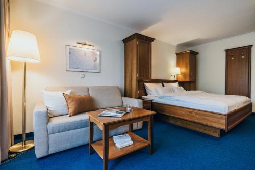 巴特法兴格Hotel Reindl Suiten & Appartments的酒店客房,配有床和沙发