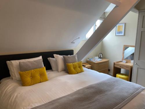 约克阿什伯恩酒店的一间卧室配有一张带黄色枕头的大床