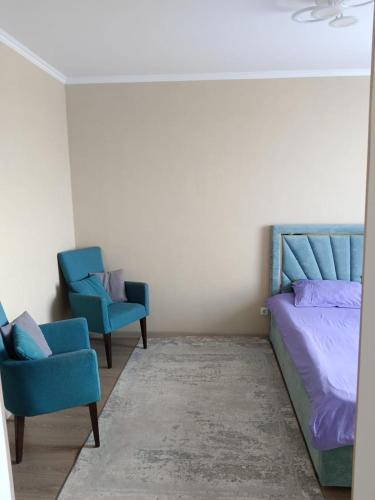 塔尔迪科尔Уют apart的一间卧室配有2把蓝色椅子和1张床