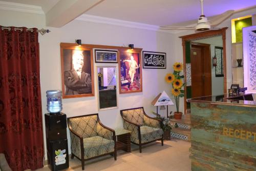 伊斯兰堡Fusion Lodge的一间设有椅子和墙上照片的等候室