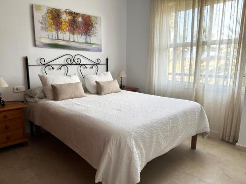 科斯塔巴伦娜Ático Barrio de los Pescadores的卧室配有白色床单和窗户。
