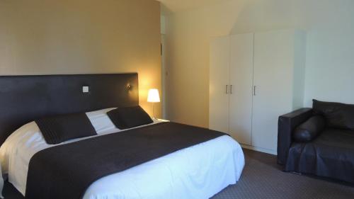克莱西克莱西高尔夫酒店 的卧室配有黑白床和椅子