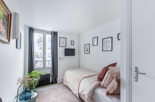 万塞讷Sauvage的卧室配有一张床,墙上配有电视。