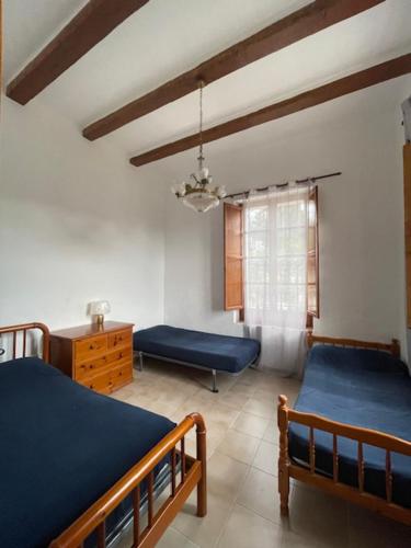 托尔托萨La Muntanya alojamiento rural turistico vacacional的一间卧室设有两张床、一张桌子和一个窗口