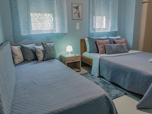 KalithiesPapa’s house的卧室设有两张床铺和蓝色的墙壁