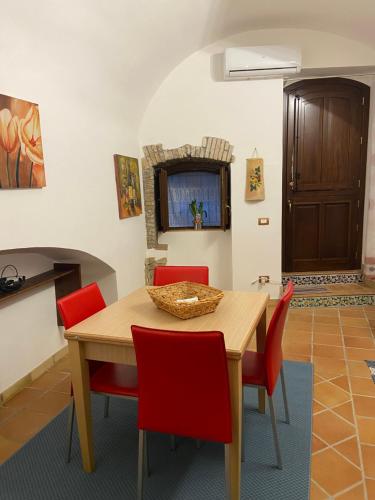 夏卡Casa Carini的一间带木桌和红色椅子的用餐室
