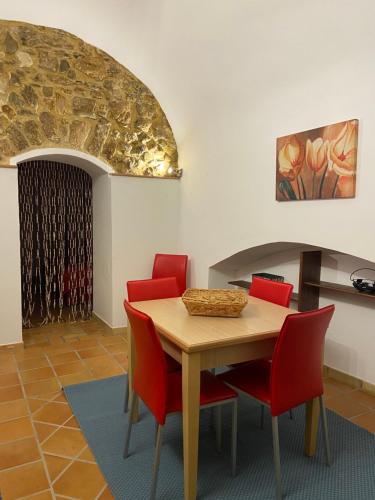 夏卡Casa Carini的一间带桌子和红色椅子的用餐室