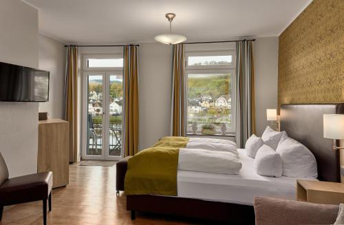 摩泽尔河畔的泽尔梅耶韦恩酒店的酒店客房设有一张床和一个大窗户