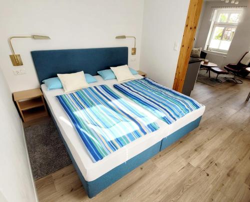 萨斯尼茨Ferienwohnung-2-in-der-Altstadt-Fam-Harder的一张大床,在房间内有一个蓝色床头板