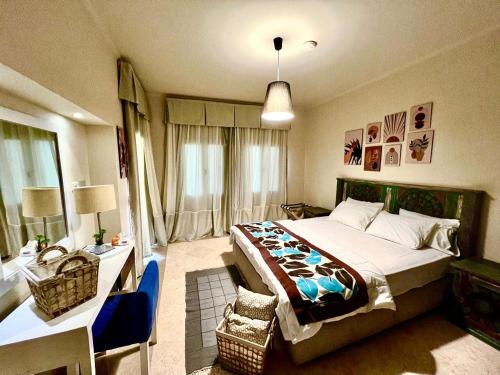 赫尔格达Azzura appartment sahl hashesh with private garden的一间卧室配有一张大床、一张桌子和一张四柱床。