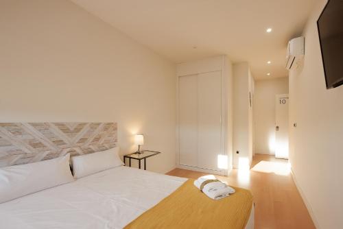 比亚努夫拉Habitación Villanubla的卧室配有白色的床和木制床头板