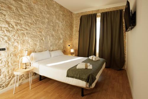 比亚努夫拉Habitación Villanubla的一间卧室设有一张大床和石墙