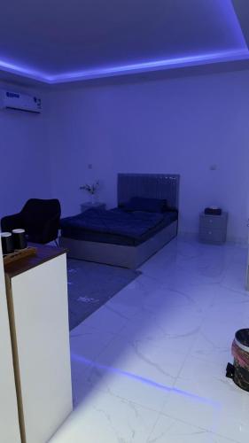 Al Bad‘فندق الاقامة السعيدة的一间设有床铺和蓝色天花板的客房