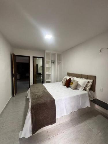 卢塞纳Bangalô no condomínio Victory em Lucena-PB的卧室配有一张带白色床单和枕头的大床。