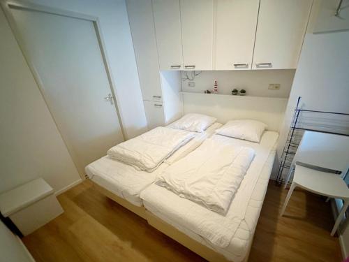 霍勒姆Kaap 10的白色的小房间,配有床和椅子