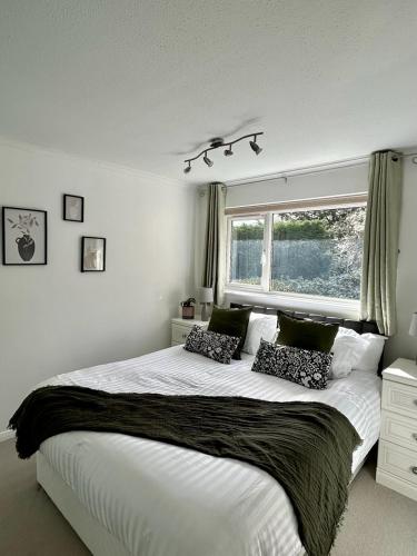 希钦Stylish 3 Bed House Hitchin的一间卧室设有一张大床和一个窗户。