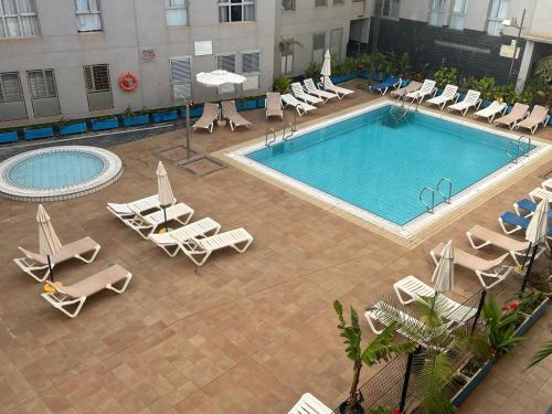 加尔达尔Acogedor apartamento con piscina yedae的享有带躺椅的游泳池的顶部景致